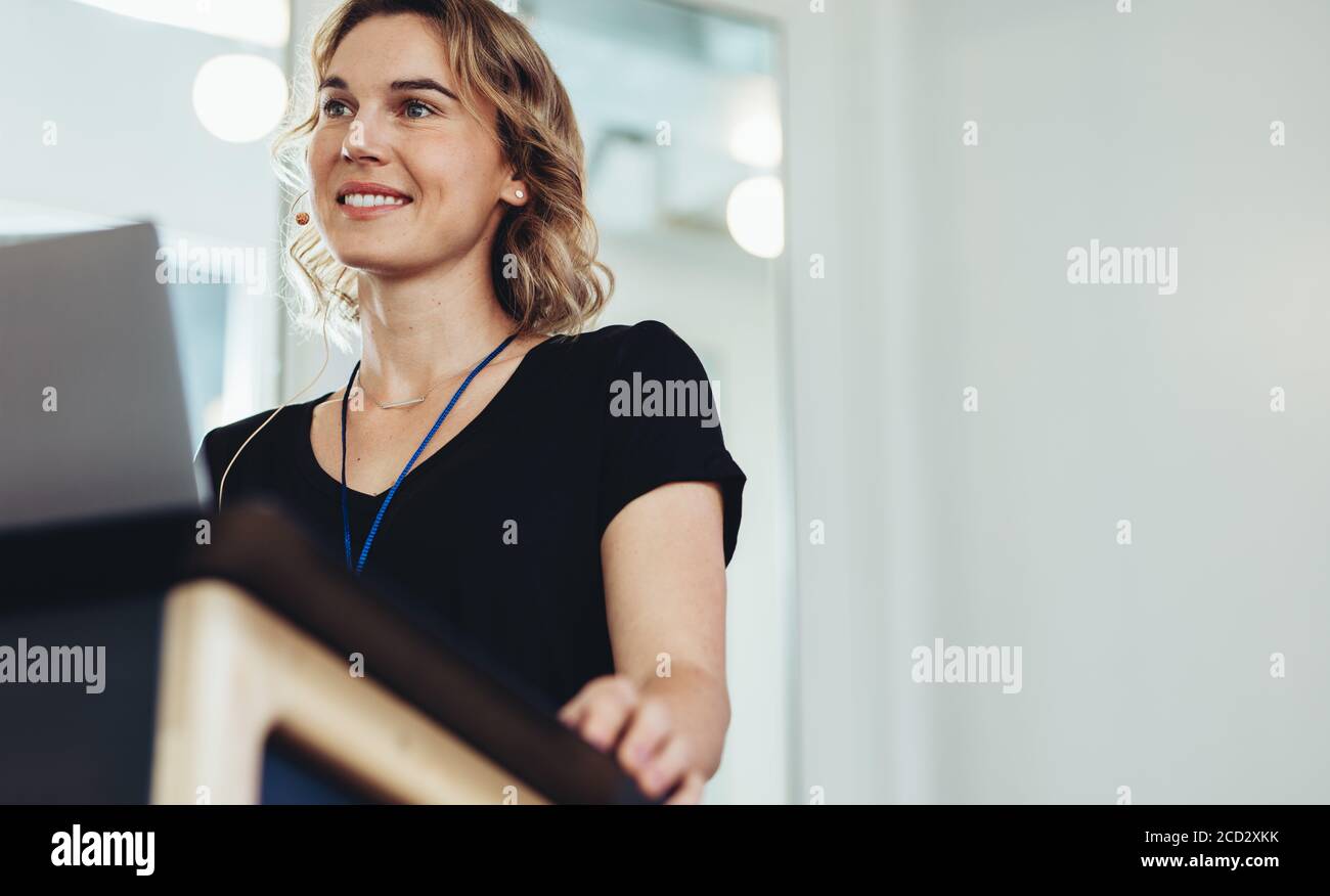 Donna imprenditore in piedi sul podio in conferenza. Donna professionista di affari che dà la presentazione in una conferenza. Foto Stock