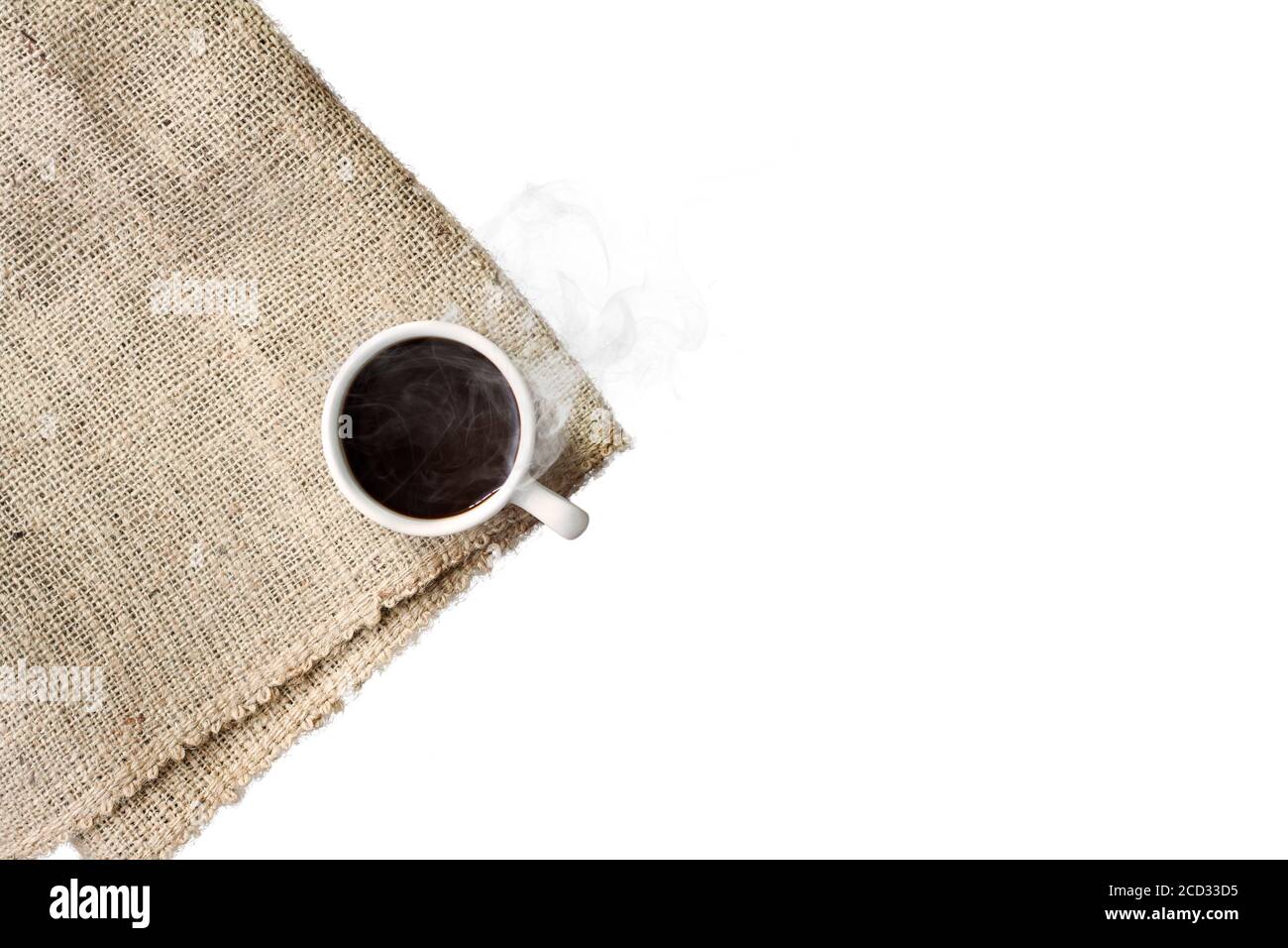 Una tazza di caffè nero con fumo su tovagliolo in sackcloth, isolato su sfondo bianco. Foto Stock