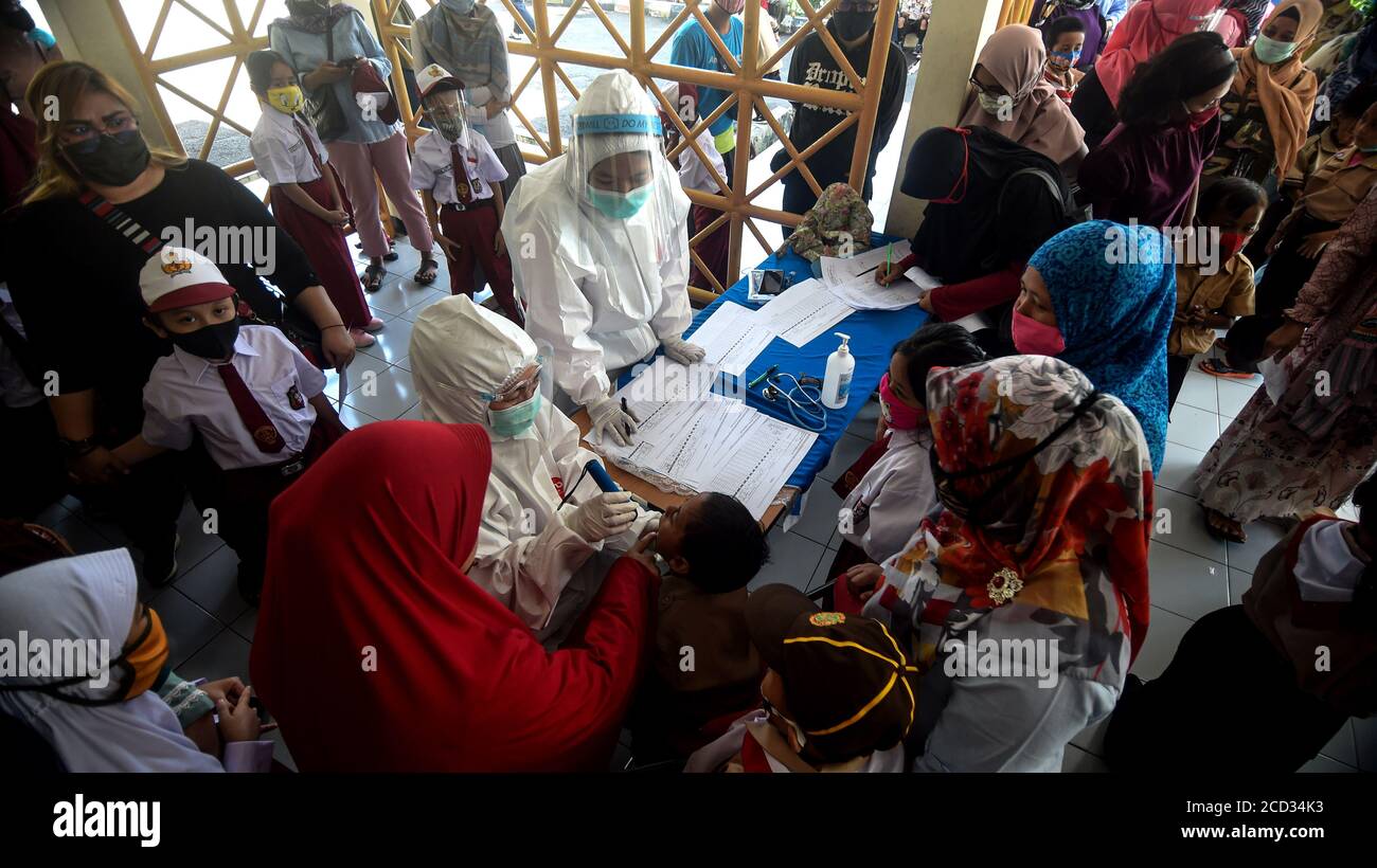 (200826) -- JAKARTA, 26 agosto 2020 (Xinhua) -- UN operatore sanitario controlla le condizioni di uno studente elementare prima di somministrare un vaccino contro il morbillo-rosolia (MR) nell'ambito dell'epidemia di COVID-19 a Giacarta, Indonesia, 26 agosto 2020. I vaccini contro il morbillo-rosolia (MR) vengono somministrati ai giovani come parte del programma del governo indonesiano per offrire un'adeguata immunizzazione dei bambini scolastici. (Xinhua/Agung Kuncahya B.) Foto Stock