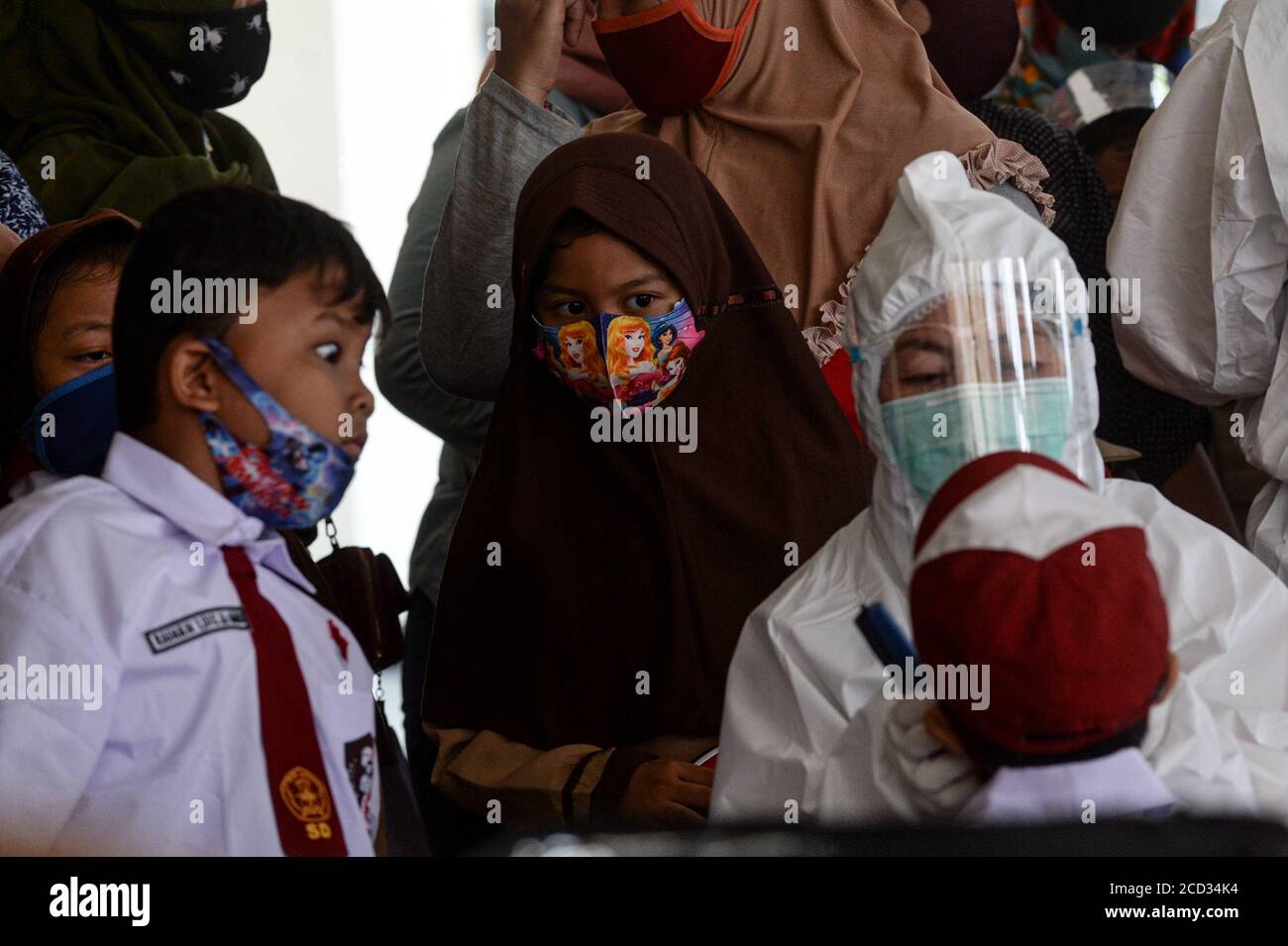 (200826) -- JAKARTA, 26 agosto 2020 (Xinhua) -- gli studenti elementari guardano un operatore sanitario che controlla i denti di uno dei loro pari prima di somministrare un vaccino contro il morbillo-rosolia (MR) in mezzo all'epidemia di COVID-19 a Giacarta, Indonesia, 26 agosto 2020. I vaccini contro il morbillo-rosolia (MR) vengono somministrati ai giovani come parte del programma del governo indonesiano per offrire un'adeguata immunizzazione dei bambini scolastici. (Xinhua/Agung Kuncahya B.) Foto Stock