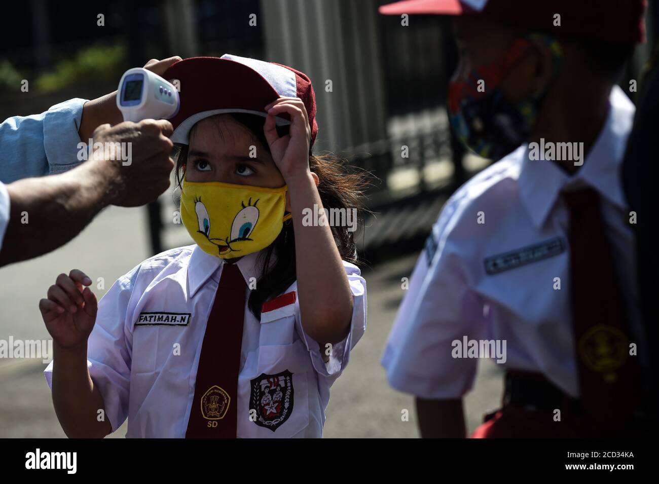 (200826) -- JAKARTA, 26 agosto 2020 (Xinhua) -- una studentessa elementare che indossa una maschera facciale ha la sua temperatura controllata prima di ricevere un vaccino morbillo-rosolia (MR) in mezzo all'epidemia di COVID-19 a Giacarta, Indonesia, 26 agosto 2020. I vaccini contro il morbillo-rosolia (MR) vengono somministrati ai giovani come parte del programma del governo indonesiano per offrire un'adeguata immunizzazione dei bambini scolastici. (Xinhua/Agung Kuncahya B.) Foto Stock