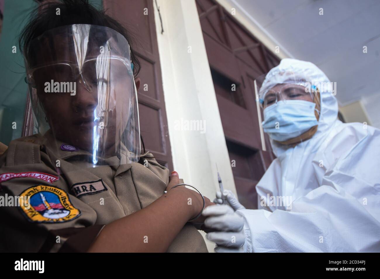 (200826) -- JAKARTA, 26 agosto 2020 (Xinhua) -- uno studente elementare che indossa uno scudo facciale riceve un vaccino contro il morbillo-rosolia (MR) effettuato da un operatore sanitario nell'ambito dell'epidemia di COVID-19 a Giacarta, Indonesia, 26 agosto 2020. I vaccini contro il morbillo-rosolia (MR) vengono somministrati ai giovani come parte del programma del governo indonesiano per offrire un'adeguata immunizzazione dei bambini scolastici. (Xinhua/Agung Kuncahya B.) Foto Stock