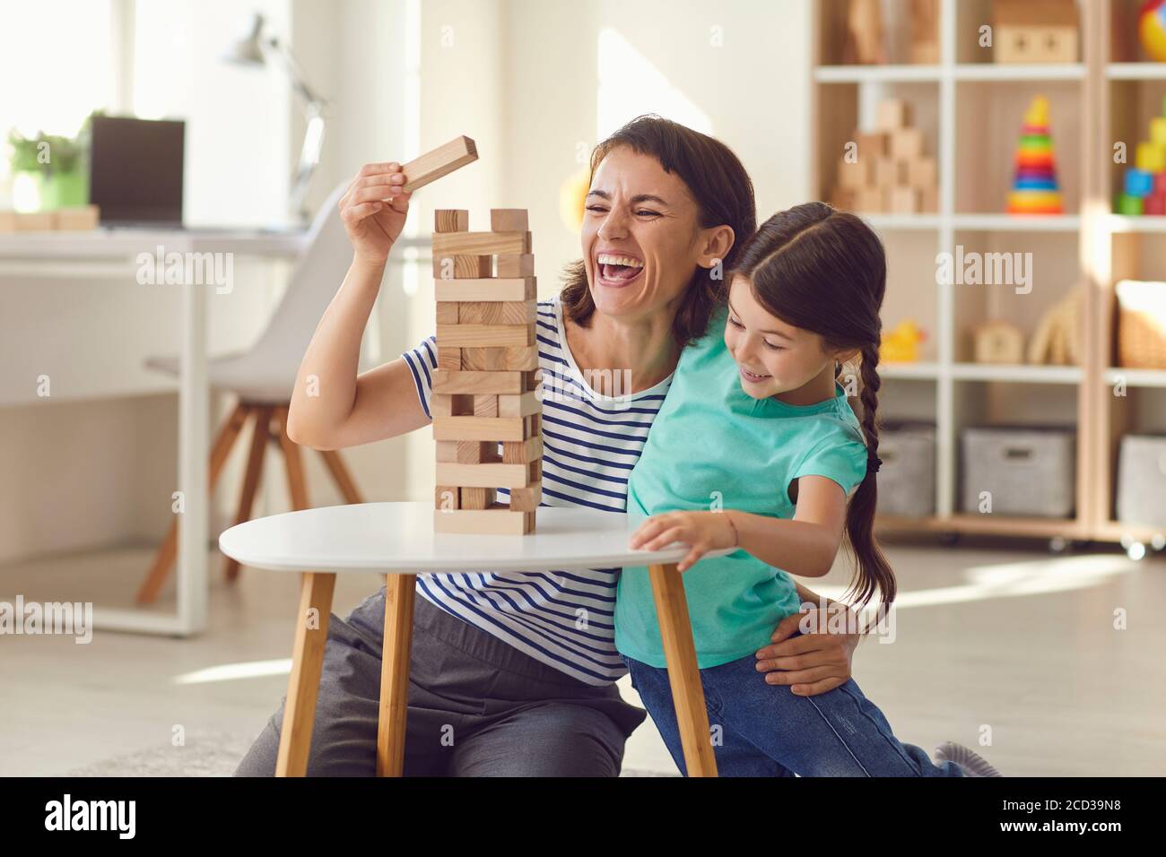 Madre e figlia giocano da tavolo a casa. Buona famiglia. Foto Stock