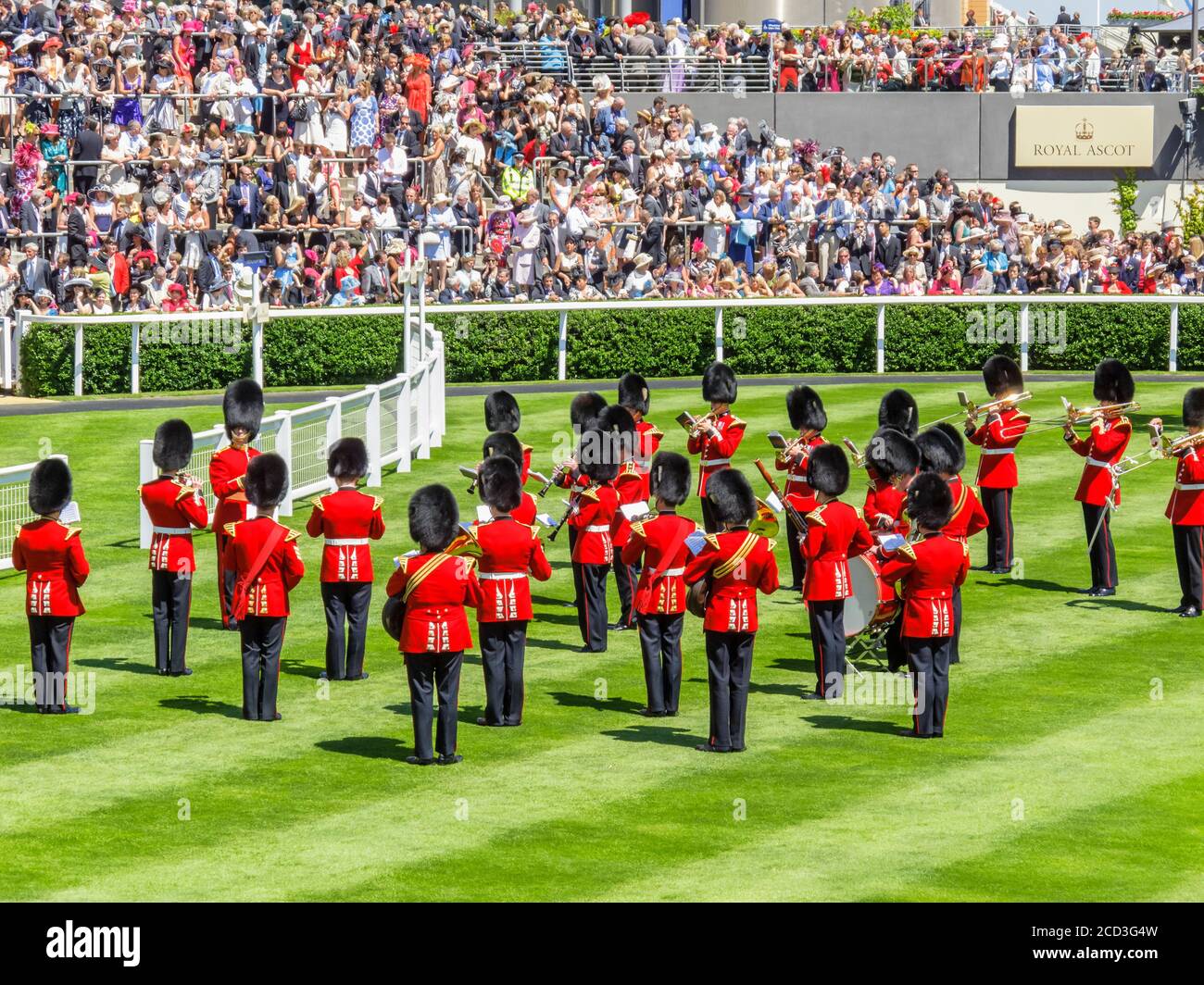 I guardiani in uniformi rosse giocano nel Parade Ring e intrattengono la folla durante Royal Ascot, l'ippodromo di Ascot, l'Ascot Berkshire Foto Stock