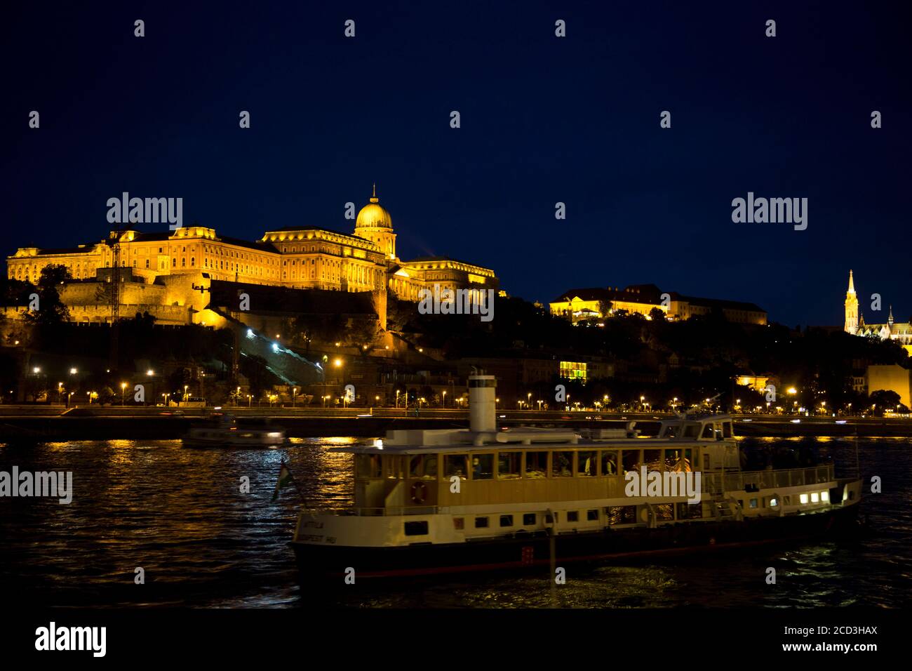 Europa dell'Est, Ungheria, Budapest, Palazzo reale (Kiralyi palota) di notte, il Danubio in primo piano Foto Stock