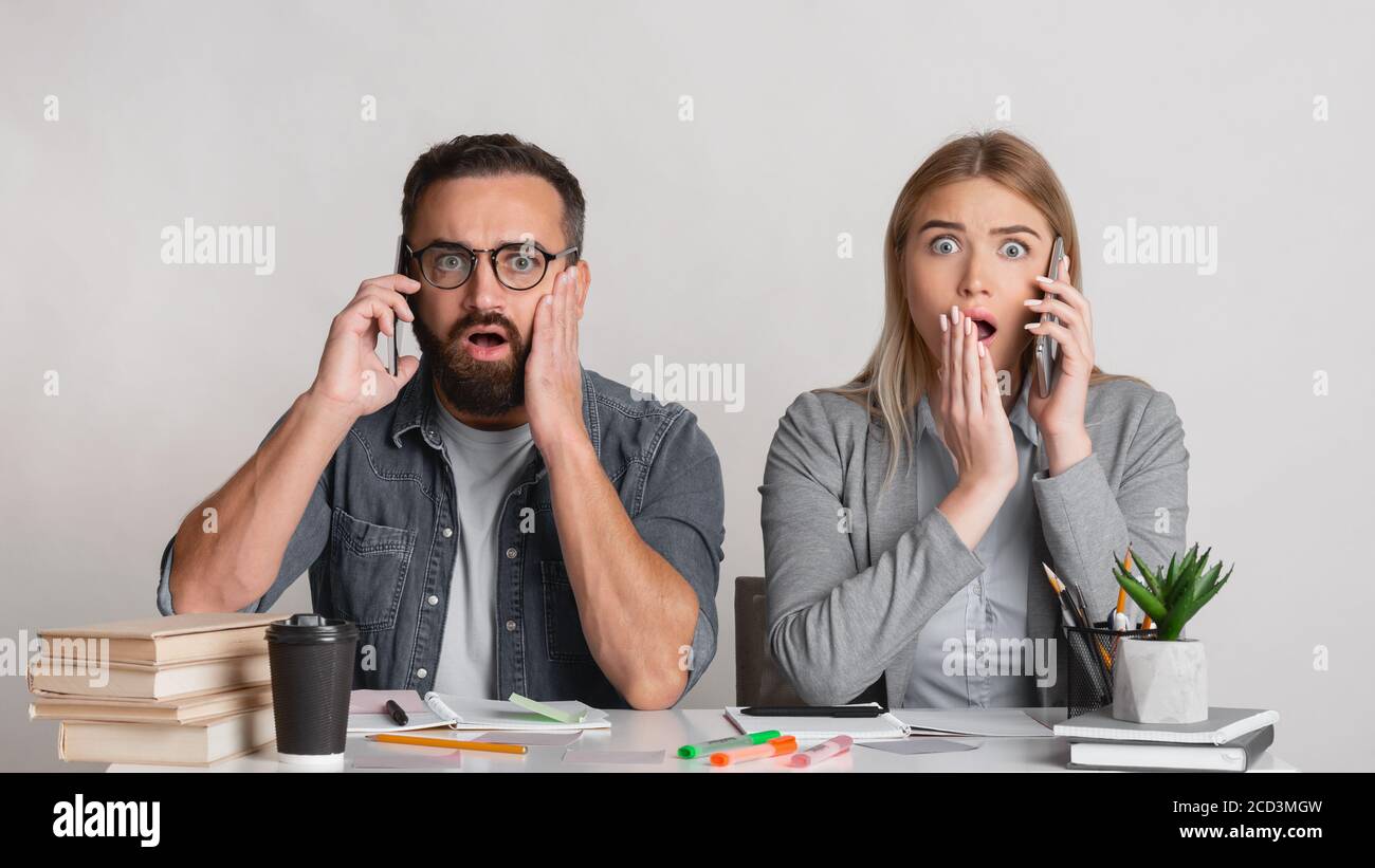 Uomo spaventato e scioccato con barba e bicchieri e con aprire le bocche sul posto di lavoro Foto Stock