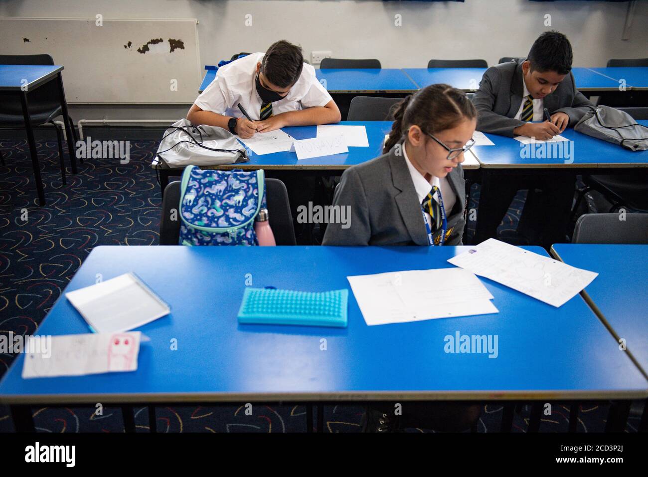 Gli alunni degli anni 7 e 11 tornano alla Manor High School di Oadby, nel Leicestershire, attualmente la scuola ha adottato una politica volontaria per quanto riguarda gli studenti che indossano rivestimenti. Foto Stock