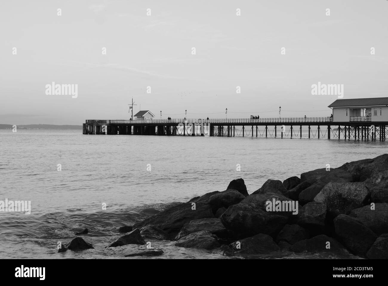 Il sole è tramontato, la gente gode di una passeggiata serale lungo la passeggiata Penarth e il molo. Penarth victorian Pavilion, un punto di riferimento ben noto nel Galles del Sud Foto Stock