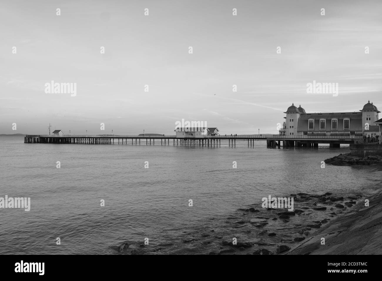 Il sole è tramontato, la gente gode di una passeggiata serale lungo la passeggiata Penarth e il molo. Penarth victorian Pavilion, un punto di riferimento ben noto nel Galles del Sud Foto Stock