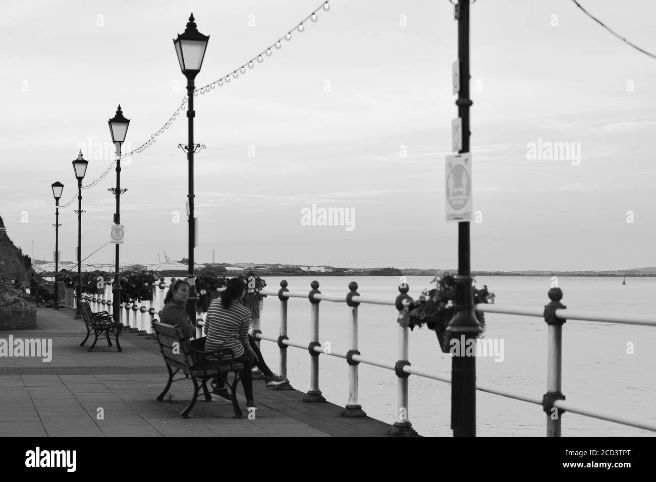 Il sole è tramontato, la gente gode di una passeggiata serale lungo la passeggiata Penarth e il molo. Penarth victorian Pavilion, un punto di riferimento ben noto nel Galles del Sud Foto Stock