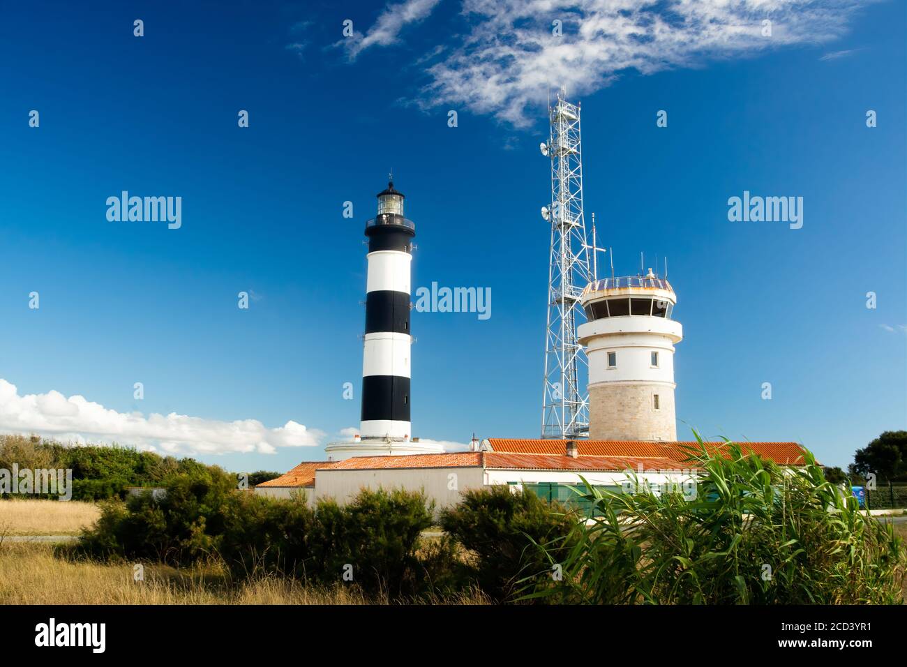 Faro con cielo blu e nuvole estive e tetto in terracotta a chassiron, Oleron Island, Francia Foto Stock
