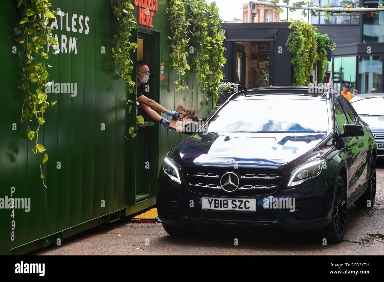 Un cliente raccoglie un hamburger senza carne dal M*** F*** Drive Thru, il primo drive-thru senza carne nel Regno Unito, il giorno in cui apre a Hackney, a est di Londra. Foto Stock