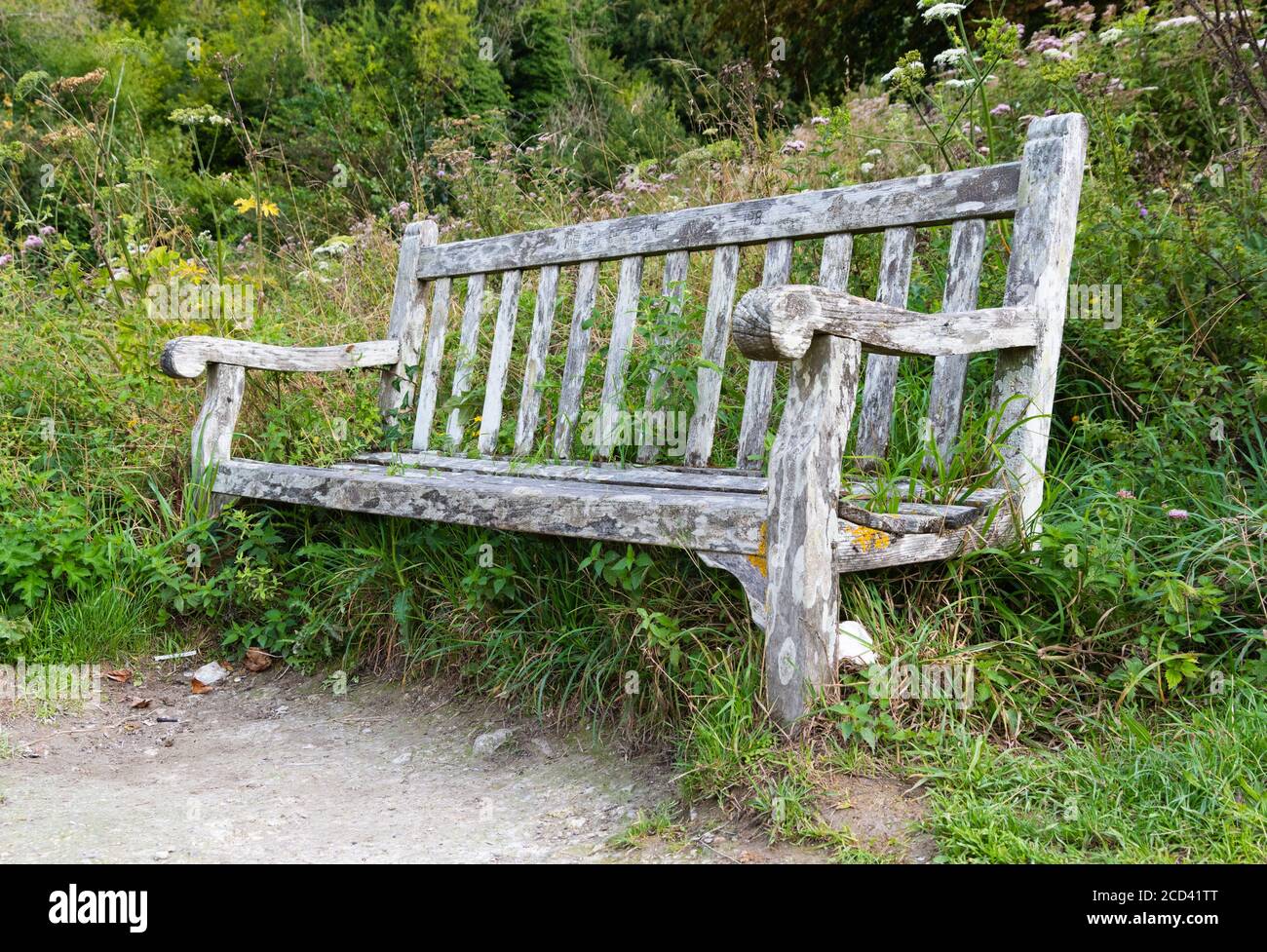 Vecchia panchina pubblica in legno marcio con nessuno seduto su di essa. Foto Stock