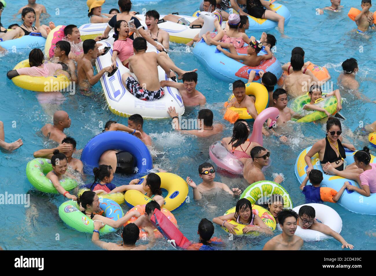 Le persone godono di acqua in una piscina in un parco acquatico come il calore estivo colpisce Chongqing a Chongqing, Cina, 25 luglio 2020. Foto Stock