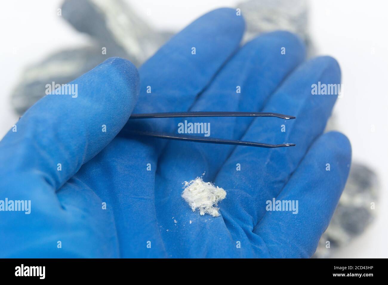Primo piano delle fibre di amianto crisotilo a mano di un uomo in guanti. L' amianto minerale si trova sul palmo in un guanto Foto stock - Alamy