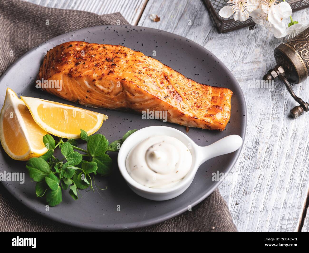 filetto di salmone arrosto al forno con limone, salsa bianca e germogli di piselli cibo sano. Foto Stock