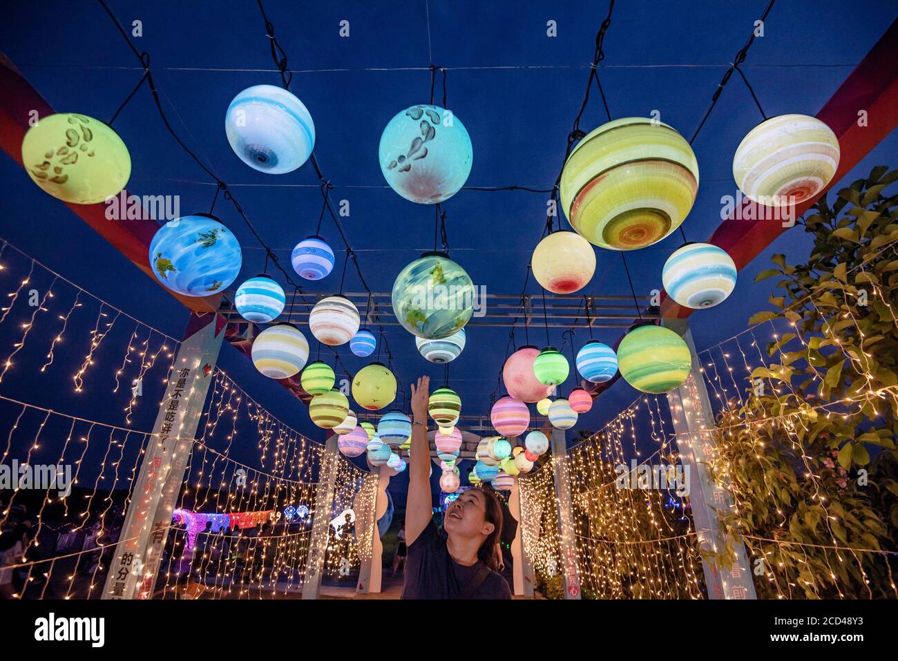 Una persona tocca una palla di luce colorata al primo festival del mulino a vento e dello spettacolo di luci nella contea di Xingan, Ji'an City, East China' Foto Stock