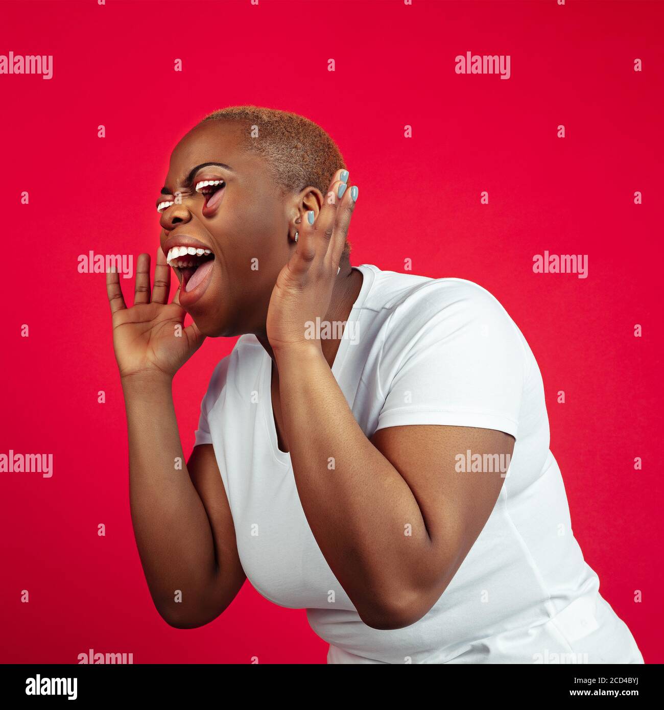 Ritratto di donna afroamericana isolato sullo sfondo dello studio. Bella modello femminile con bocca invece occhi. Concetto di emozioni umane, espressione facciale, vendite, pubblicità. Collage surreale, altamente teso. Foto Stock