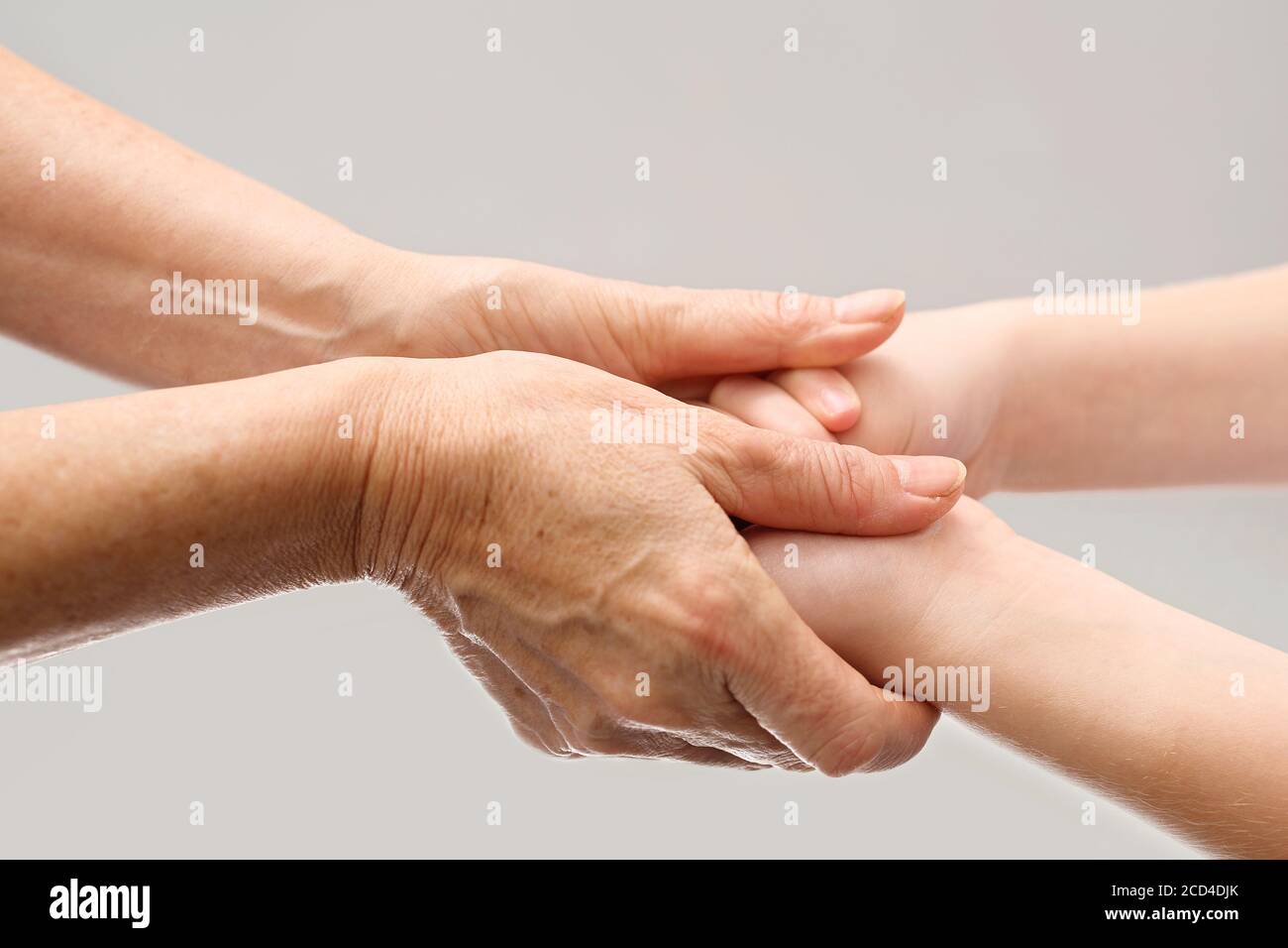 Cura di una persona anziana. Una mano di aiuto. Le mani vecchie e giovani si tengono in un gesto di cura. Foto Stock