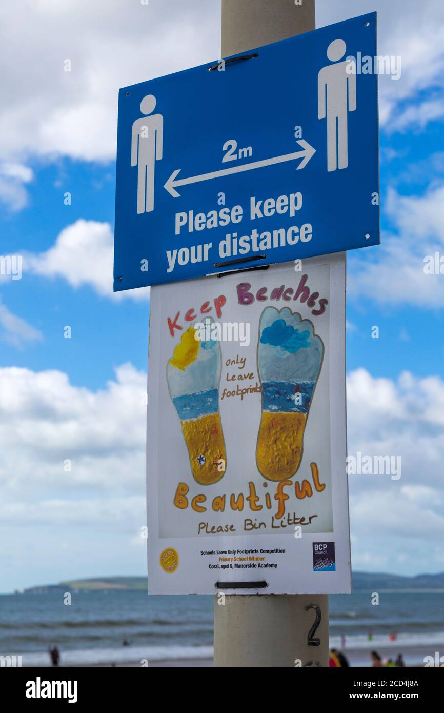 Mantenere le spiagge belle si prega di bin letter lasciare solo impronte si prega di mantenere la distanza 2m a parte i cartelli sulla passeggiata, Bournemouth, Dorset UK nel mese di agosto Foto Stock