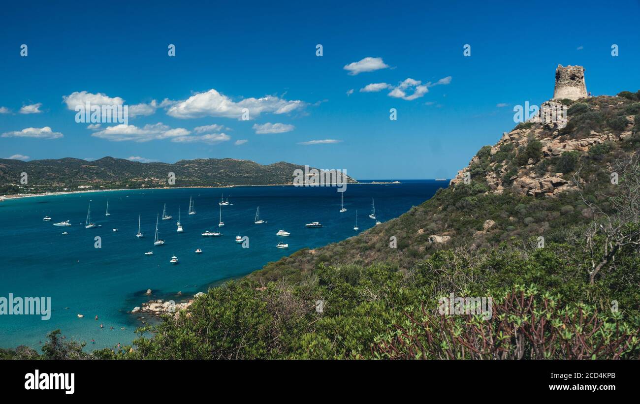 Vista panoramica di una splendida baia con yacht, acqua blu e vecchia torre. Baia di Porto Giunco dalla vecchia torre di Porto Giunco. Sardina, Italia Foto Stock