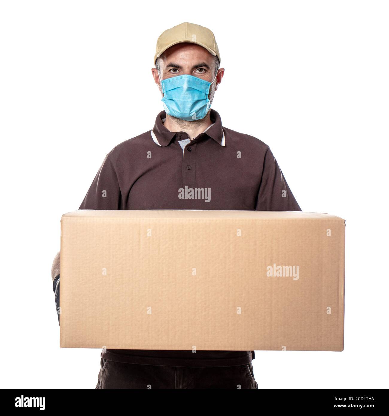 Corriere uomo caucasico con maschera e grande pacchetto da consegnare. Spedizioni durante la pandemia coronavirus Foto Stock