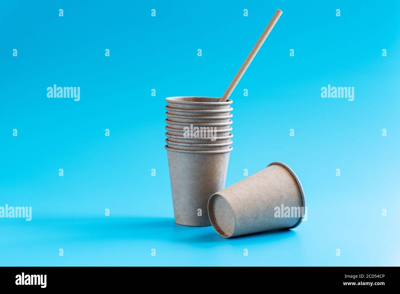 Pila di tazze di carta monouso su sfondo blu. Stoviglie eco-compatibili. Concetto di riciclaggio. Tema zero rifiuti. Spazio di copia Foto Stock
