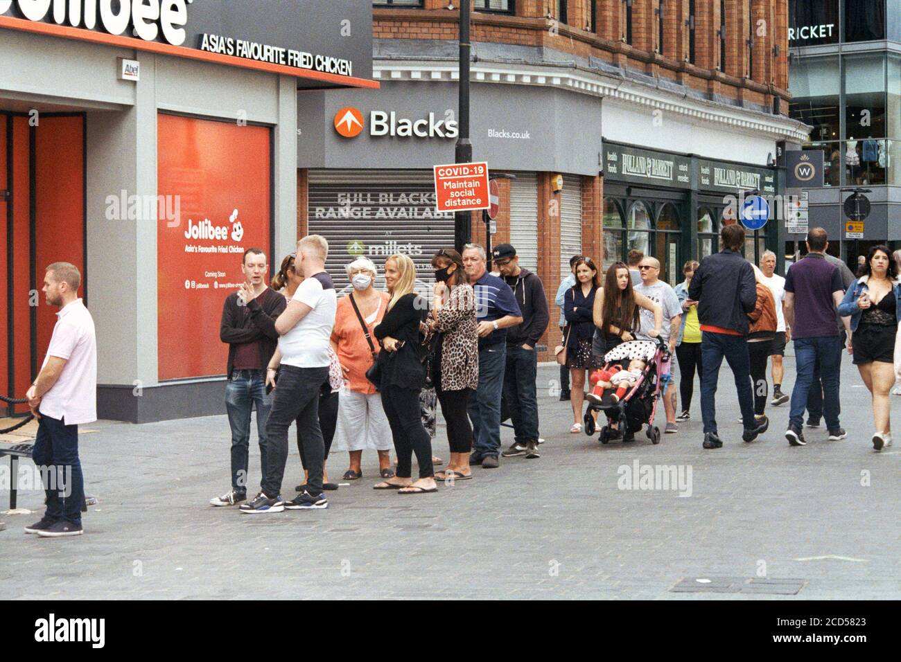 Liverpool, Regno Unito - 8 agosto 2020: La gente si fila sulla strada per aspettare di entrare nel negozio. Foto Stock