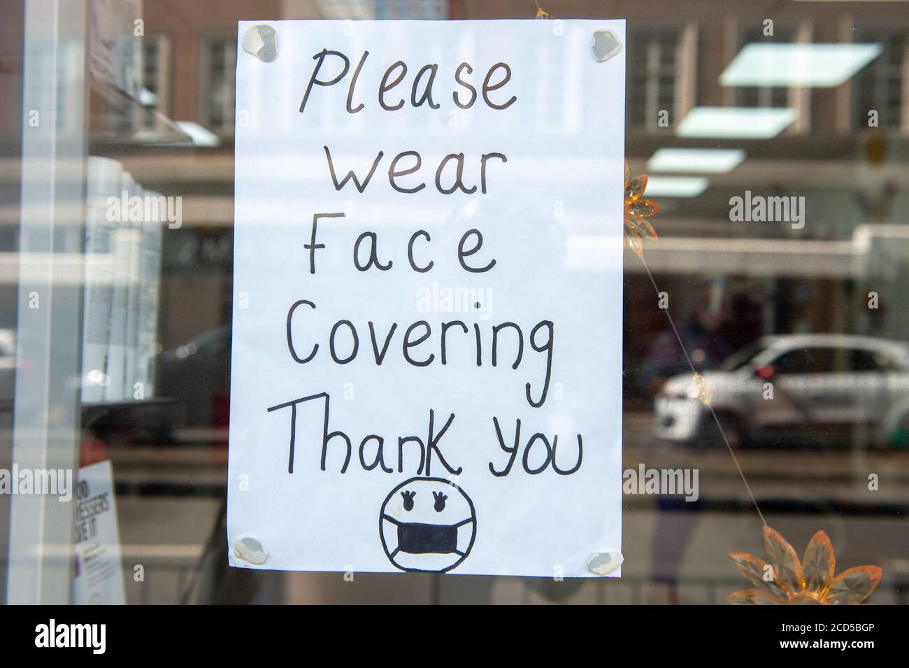Staines-upon-Thames, Surrey, Regno Unito. 26 agosto 2020. Un cartello di copertura per il viso da indossare in una vetrina. Credito: Maureen McLean/Alamy Foto Stock