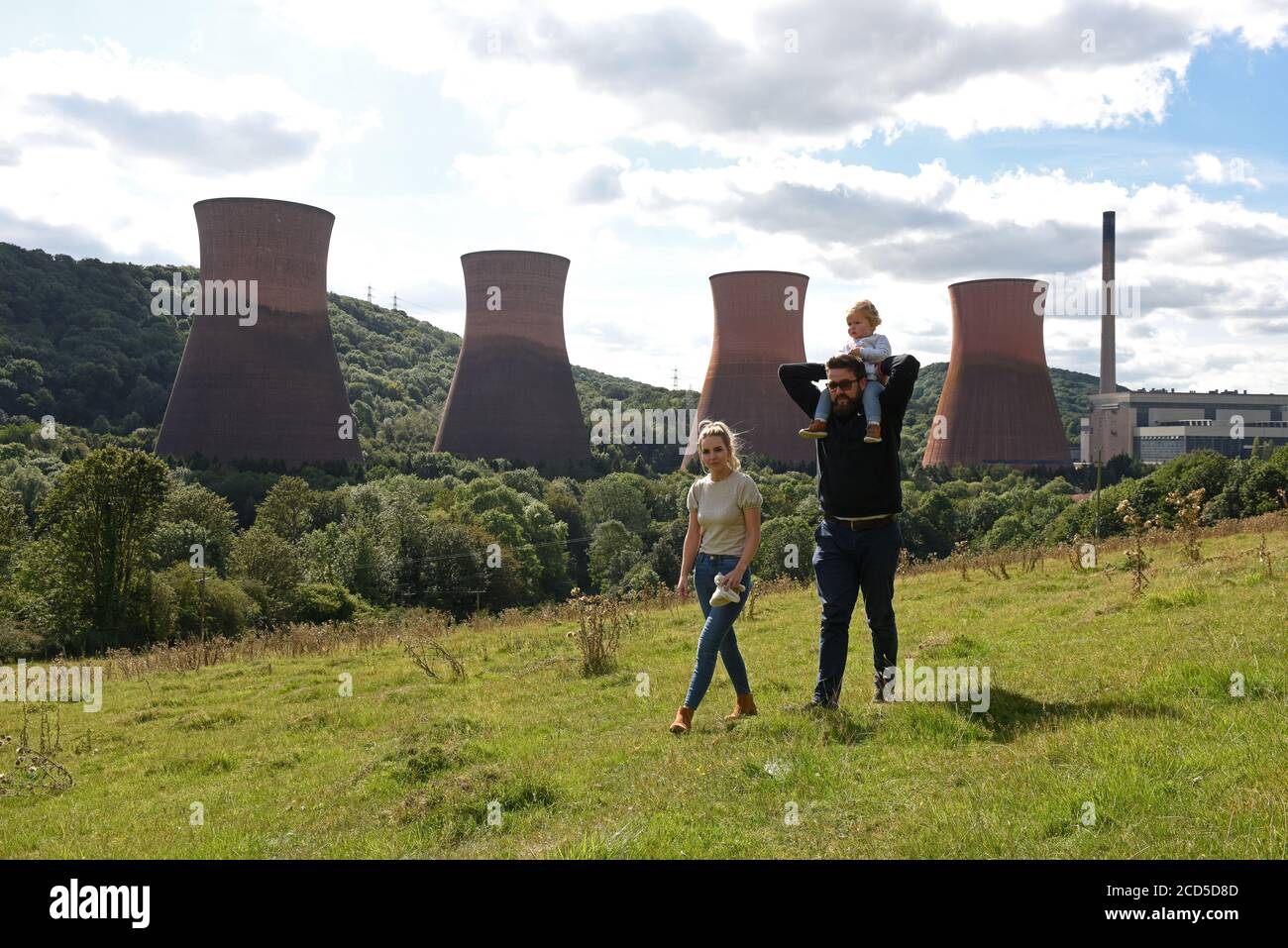 La famiglia cammina su Strethill Meadow con vista sulle torri di raffreddamento della centrale elettrica di Ironbridge. Foto Stock