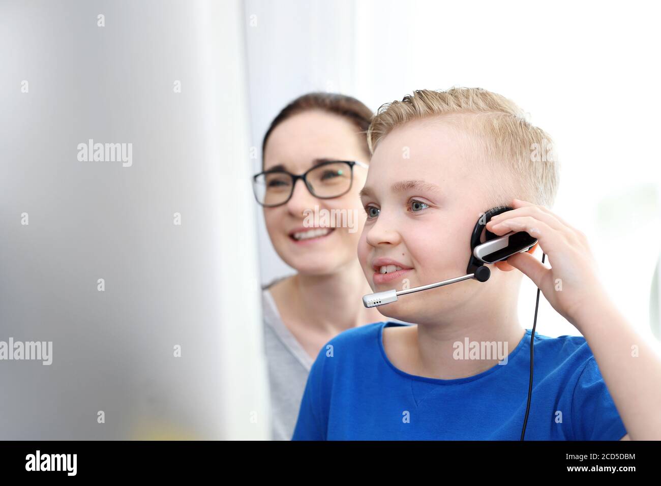 Scuola di casa, formazione online. La mamma aiuta il bambino a imparare online. Foto Stock