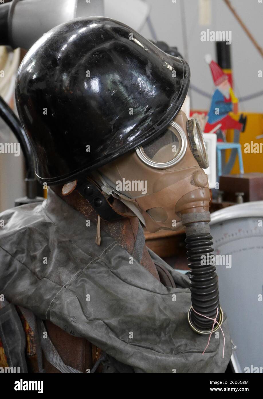 Maschera a gas Antique War Time con tubo respiratorio e air bag, insieme al casco in acciaio indossato su un manichino Foto Stock