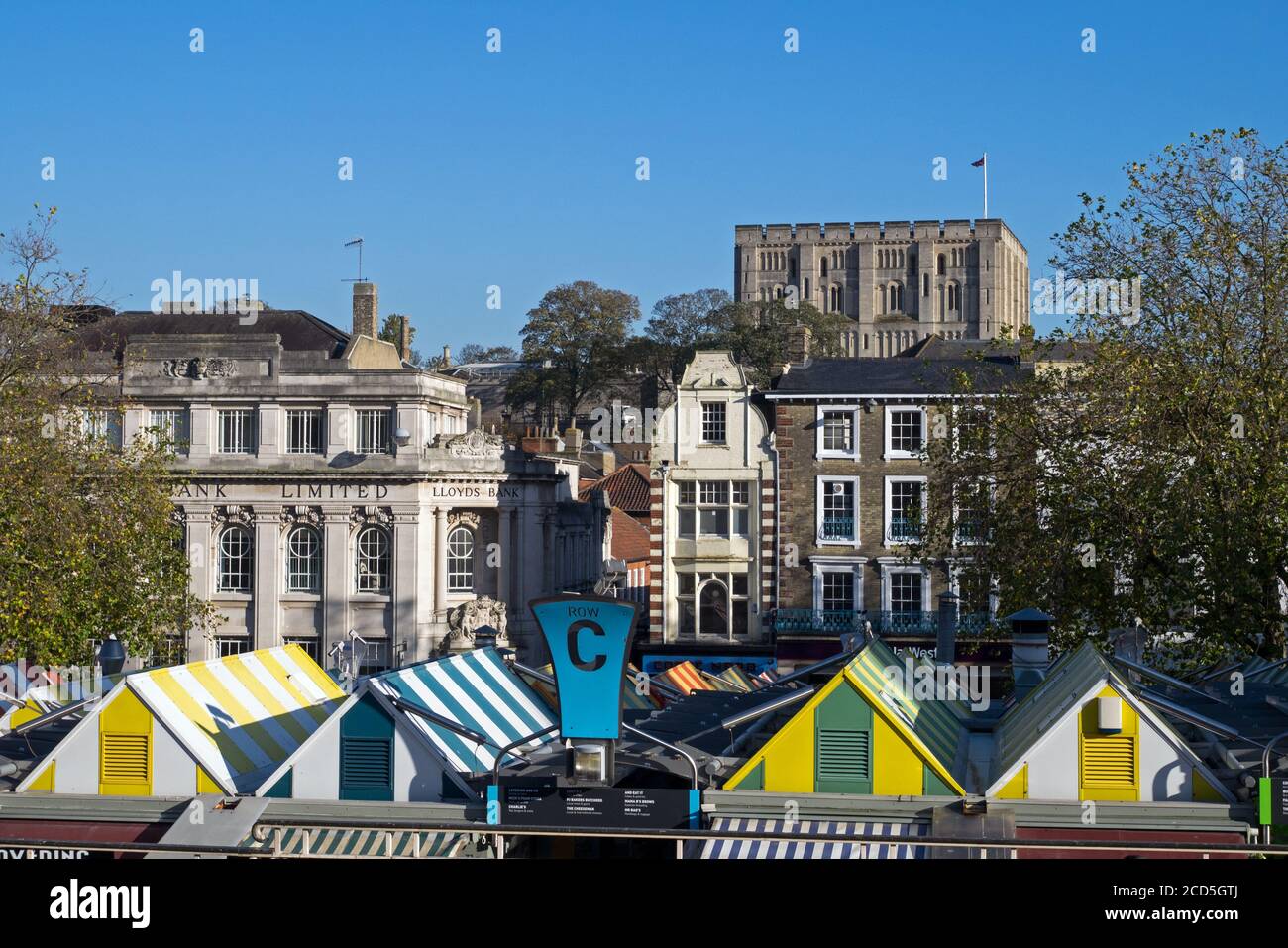 Norwich Market con i suoi colorati Swnings Striped, con il Castello che sorge sopra la Città, Norwich, Norfolk, Inghilterra, Regno Unito Foto Stock