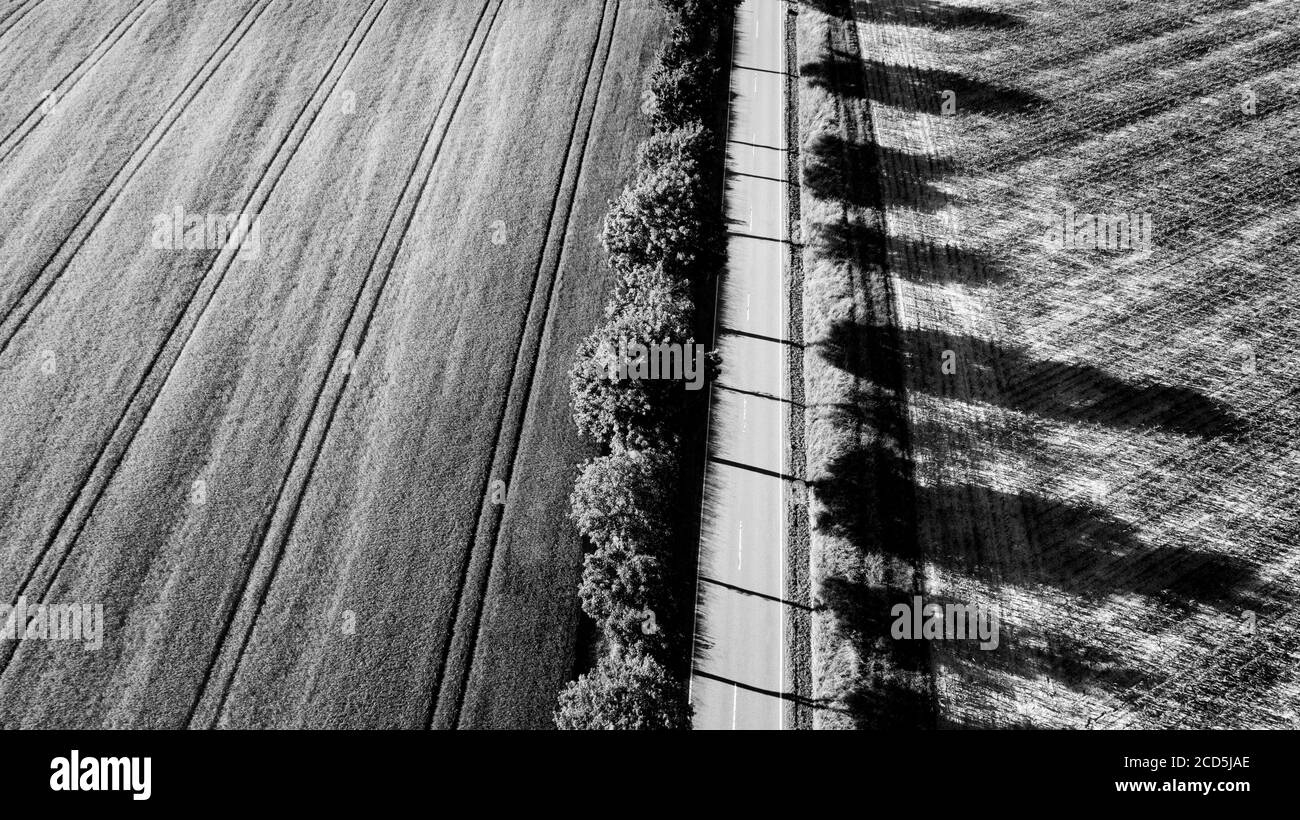 Vista aerea della strada attraverso il paesaggio rurale in nero e. bianco Foto Stock