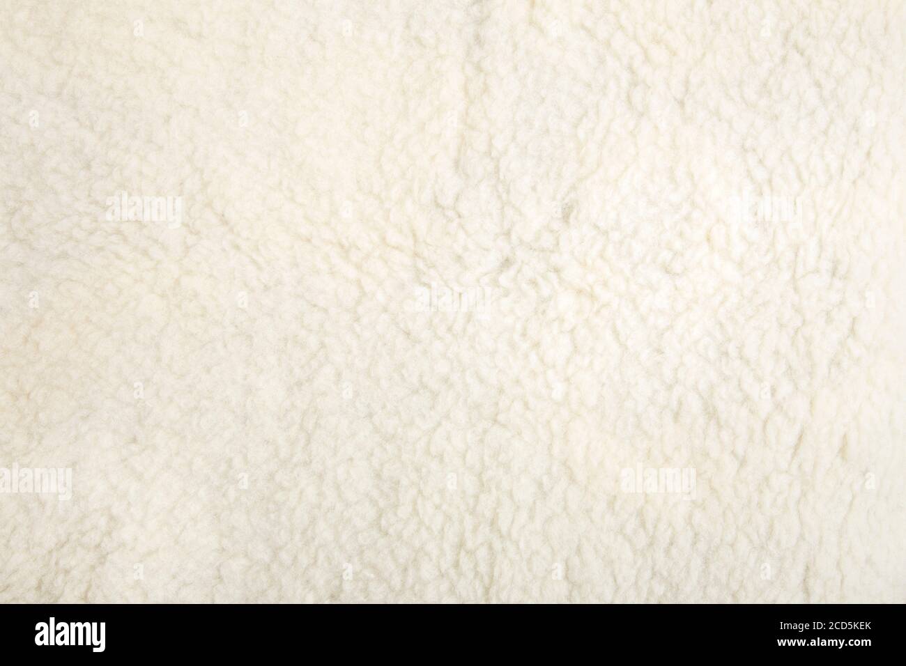 Vista dall'alto del plaid in tessuto bianco morbido in pelle di pecora. Sfondo caldo e accogliente. Foto Stock