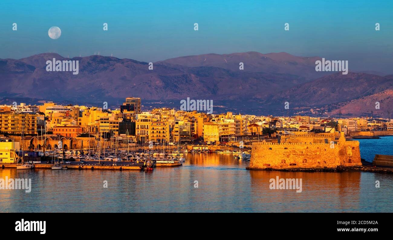 La prima luce del mattino al vecchio porto di Candia, Creta, Grecia. A destra, il castello di Kules. Sullo sfondo, montagna Psiloritis. Foto Stock