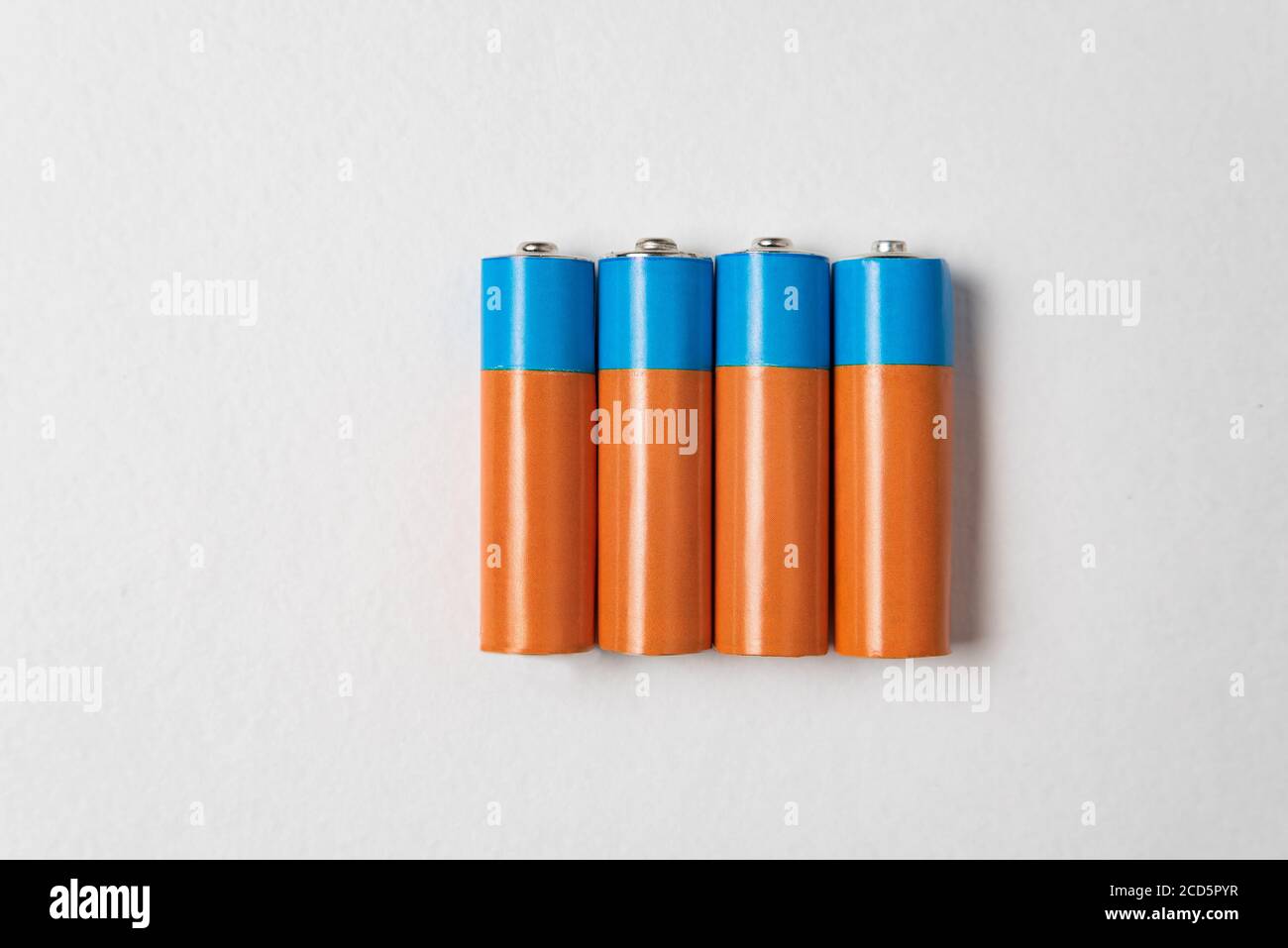 Quattro batterie alcaline AA su sfondo bianco. Batteria principale per alimentatori personali Foto Stock
