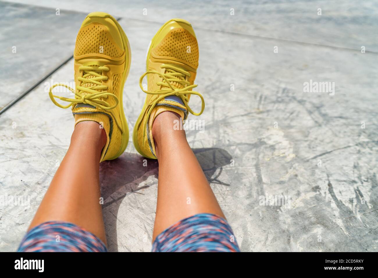Sneakers gialli ragazza che indossa stile di moda activeWear scarpe da running colorate in palestra all'aperto. Selfie POV di calzature Foto Stock
