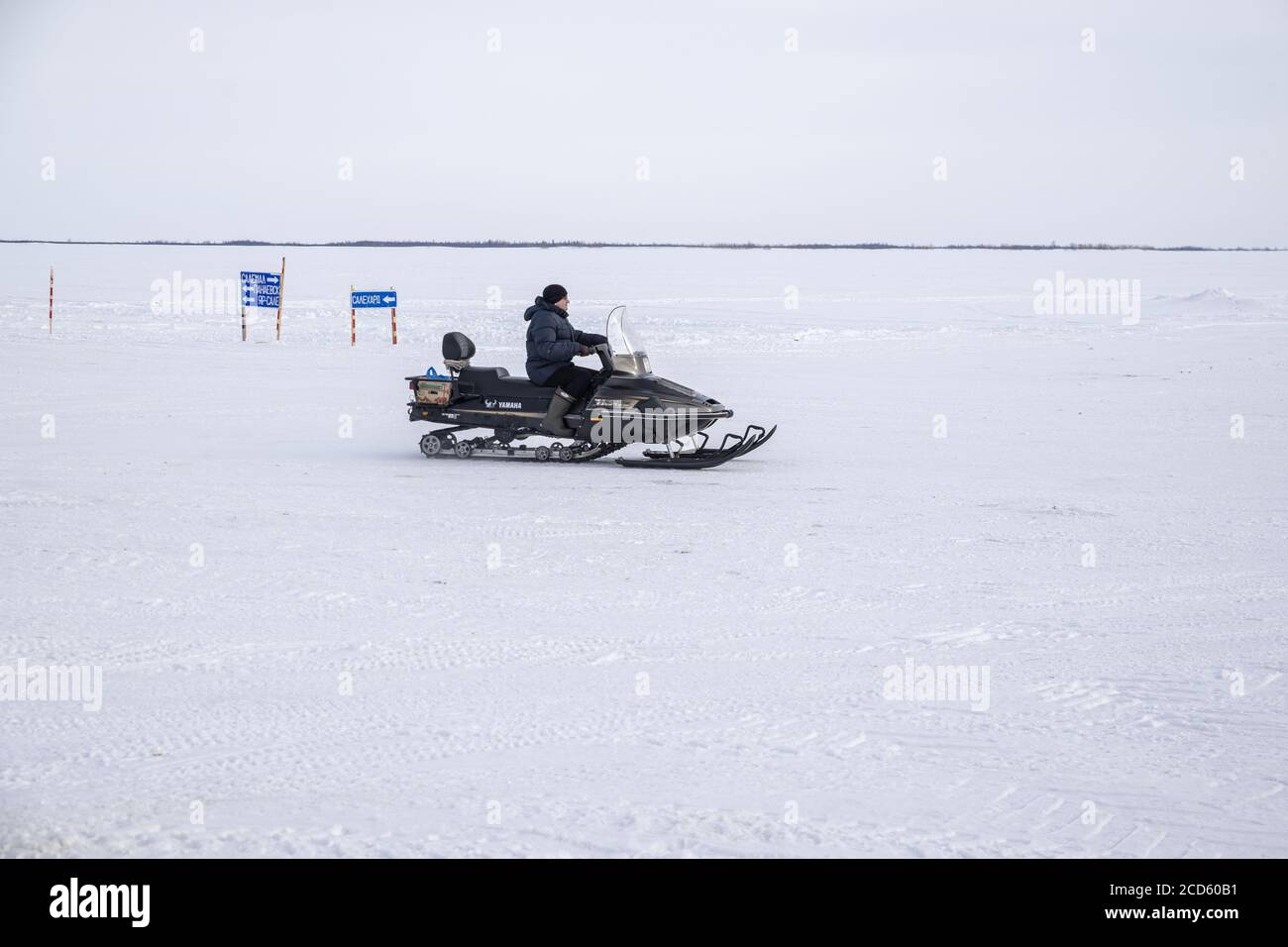 Un uomo Nenet che guida una motoslitta sulle acque ghiacciate del fiume OB, Yamalo-Nenets Autonomous Okrug, Russia Foto Stock