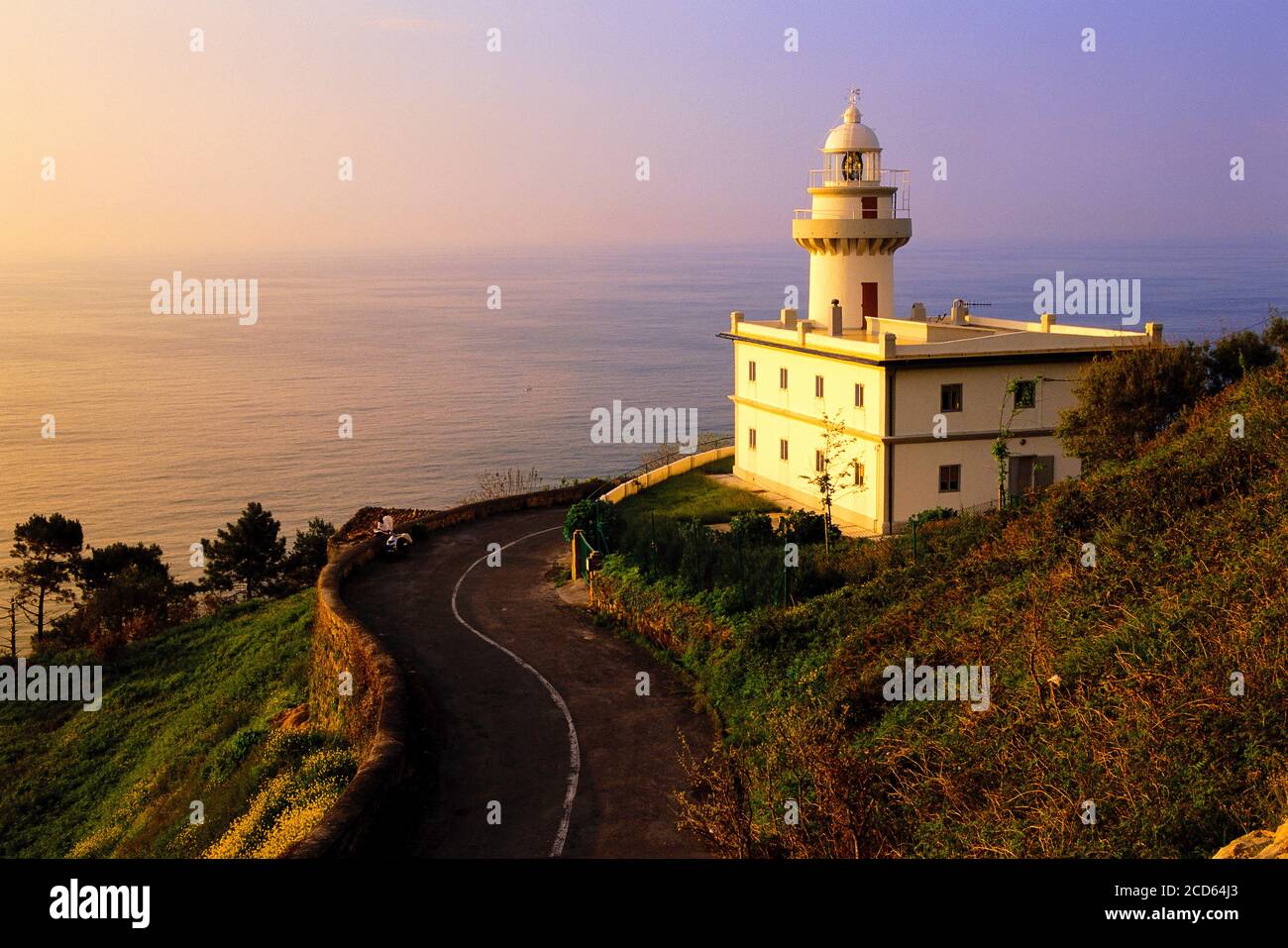 Faro in riva al mare al tramonto, San Sebastian, Paesi Baschi, Spagna Foto Stock