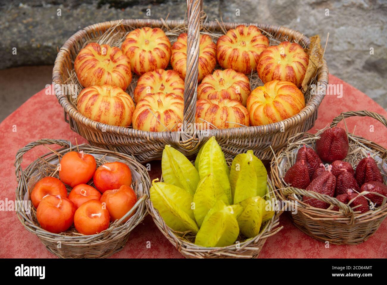 Candele a forma di frutta fatte a mano ai cestini come souvenir a Vezelay, Francia Foto Stock