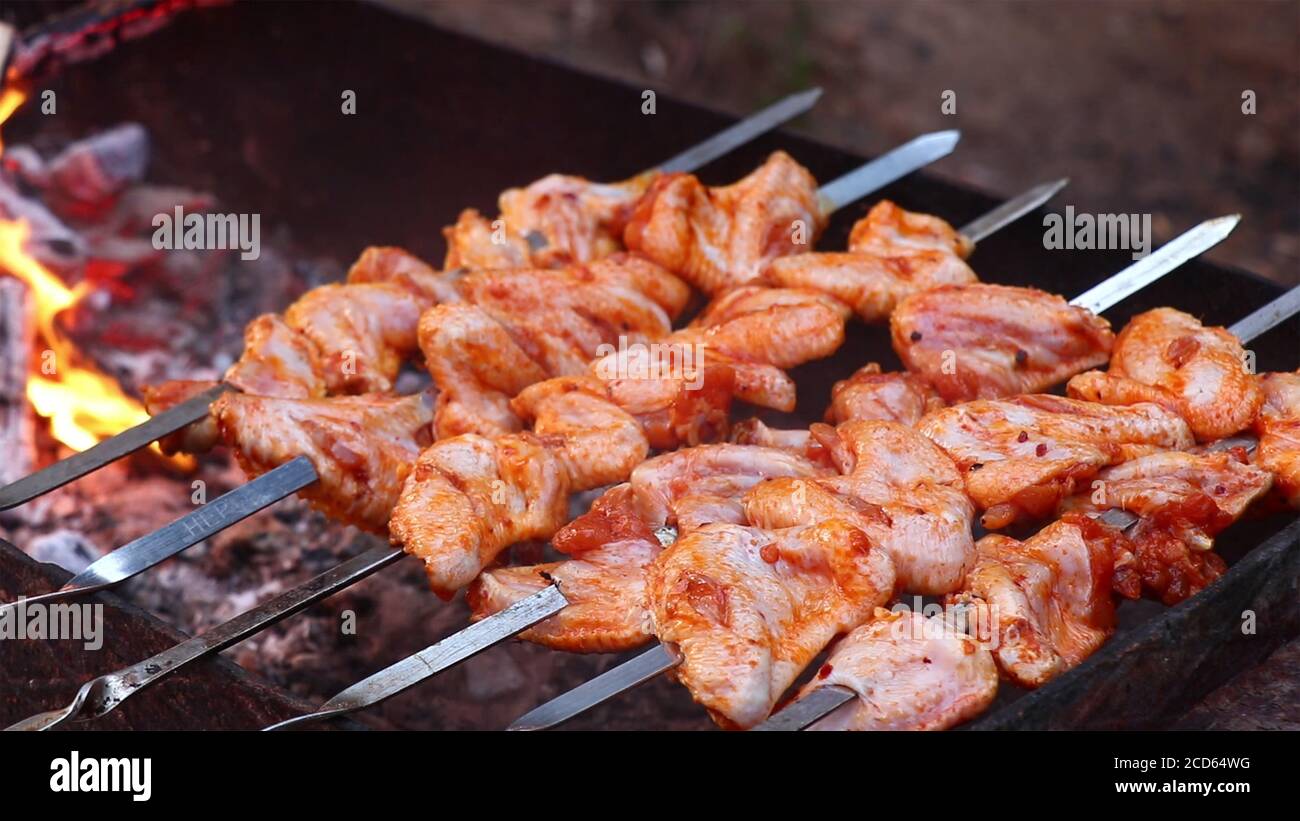 Ali di pollo e succulenti kebab arrostiti al barbecue. Cucina kebab su spiedini. Carne di pollo su spiedini. Foto Stock