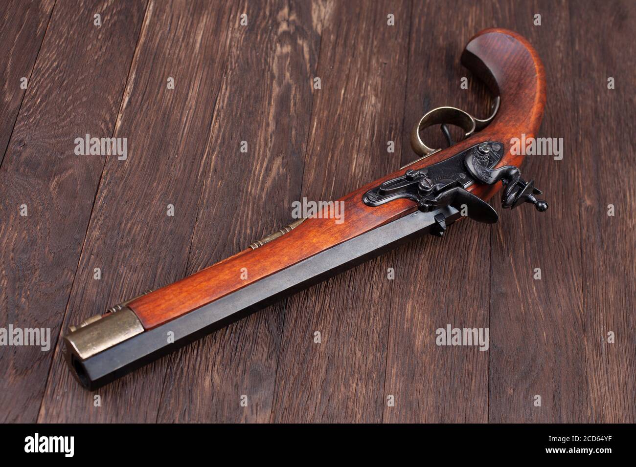 vecchia pistola retrò muso flintlock su scrivania in legno Foto Stock