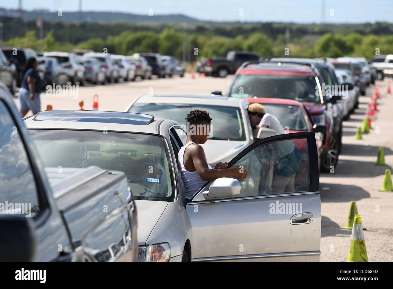 Austin, Texas USA 26 agosto 2020: Centinaia di auto provenienti dalla costa orientale del Texas e sud-ovest della Louisiana aspettano in fila un centro di evacuazione dell'uragano Laura, creato dai funzionari di Austin presso le aree di parcheggio del circuito delle Americhe. Gli autisti che arrivano in anticipo hanno ricevuto buoni per le camere d'hotel. Una volta esauriti, gli autisti sono stati indirizzati ad altri centri di evacuazione a Waco e Dallas. Laura dovrebbe fare la caduta di terra durante la notte come una tempesta di categoria 4 e devastare lungo le coste del Texas e della Louisiana e l'entroterra. Credit: Bob Daemmrich/Alamy Live News Foto Stock