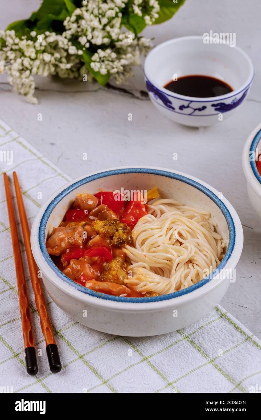 Teriyaki di pollo con peperoni, broccoli e tagliatelle in ciotola con bastoncini. Vista dall'alto. Foto Stock