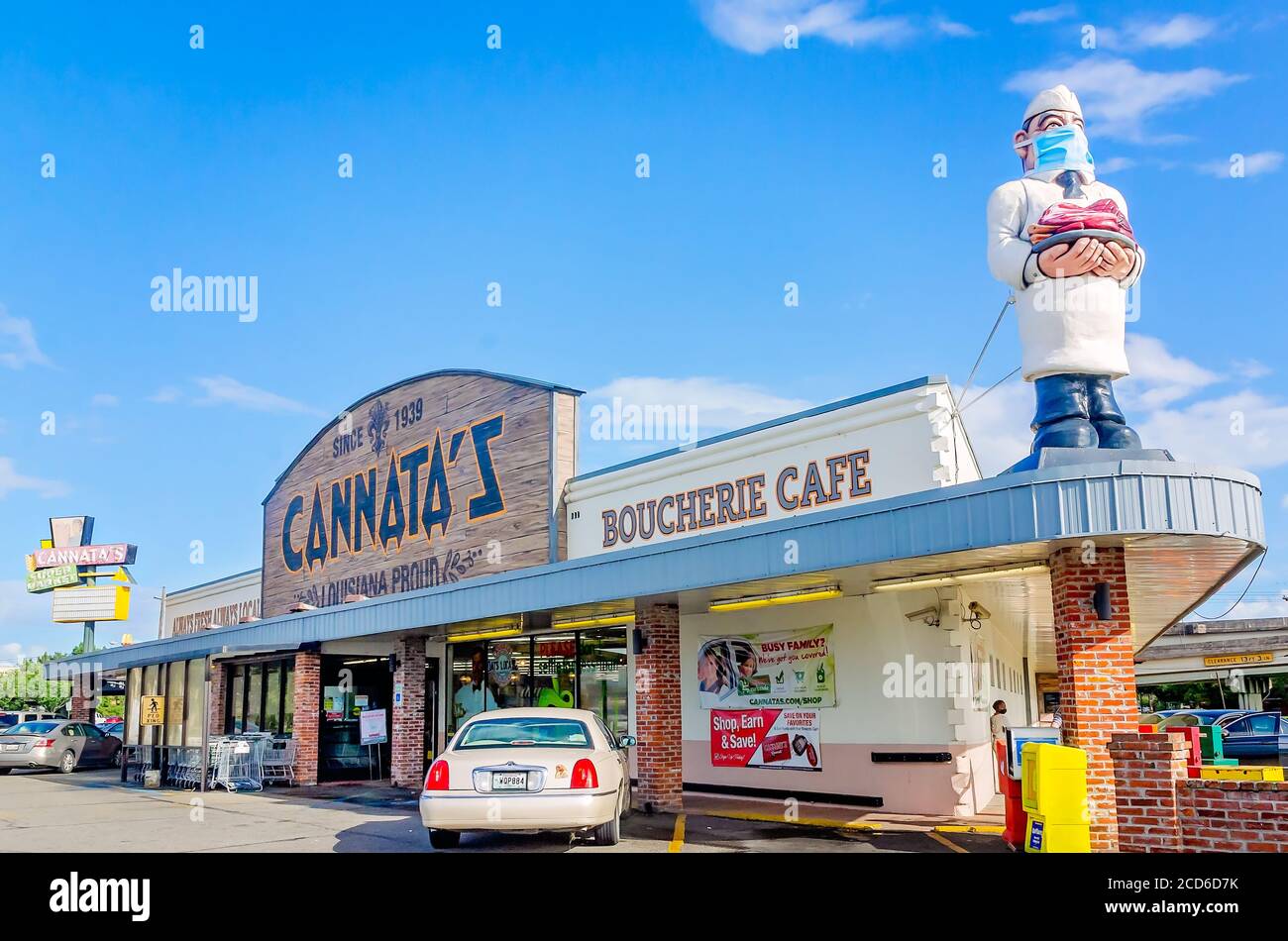 La statua del macellaio sul tetto del mercato di Cannata indossa una maschera durante la pandemia COVID-19, 25 agosto 2020, a Morgan City, Louisiana. Foto Stock