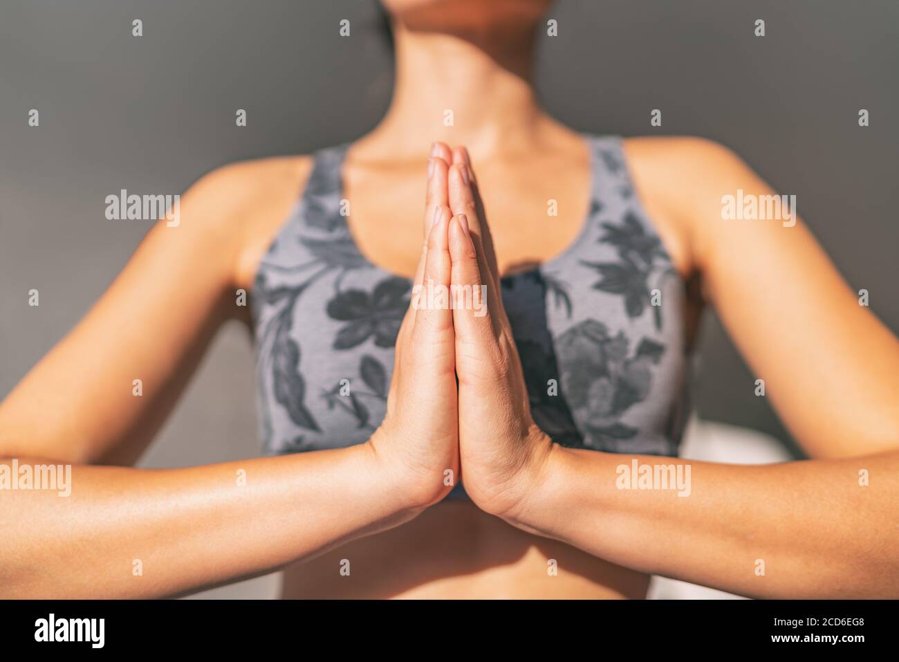 Yoga namaste donna meditando yoga mudra a mani chiuse insieme in preghiera posa pregare per gratitudine. Meditazione Zen benessere al sole del mattino Foto Stock
