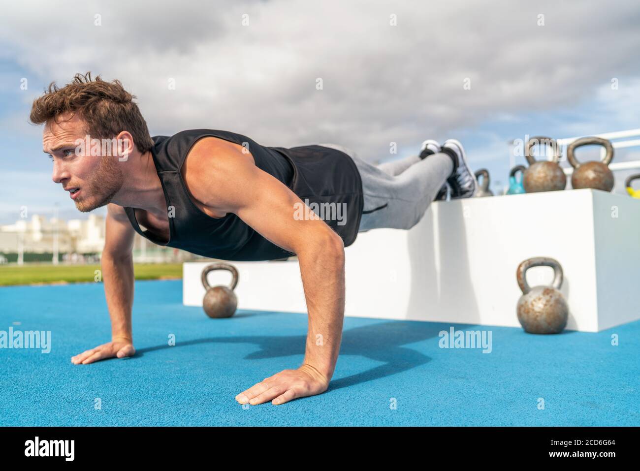 Declino spingere su uomo fitness facendo forza esercizio di allenamento spinta in su presso la palestra all'aperto con piedi rialzati Foto Stock