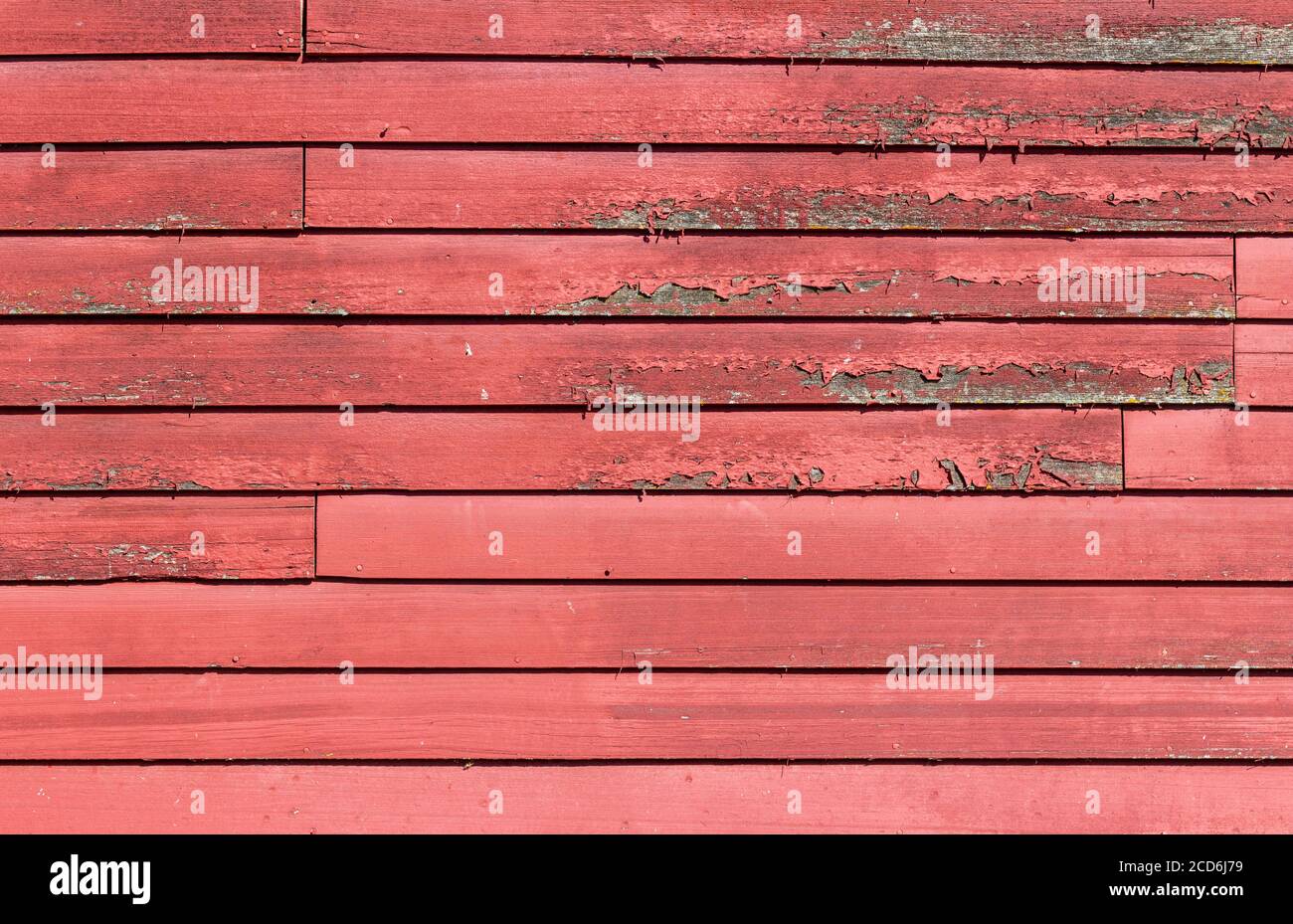 Primo piano texture sfondo vista di un antico lap di legno parete laterale con superficie resistente agli agenti atmosferici e vernice rossa Foto Stock