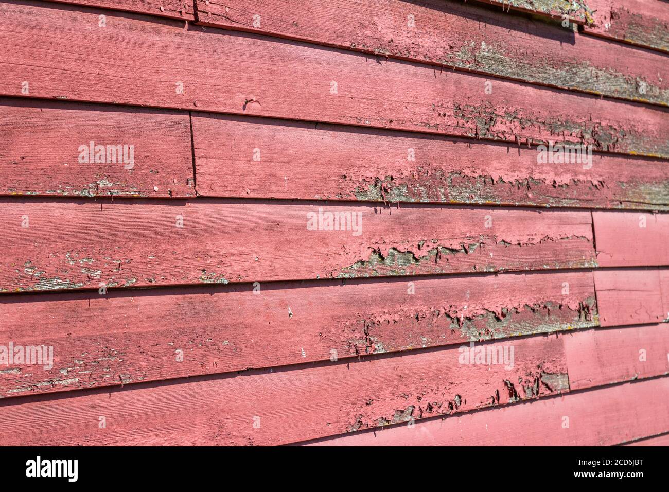 Primo piano texture sfondo vista di un antico lap di legno parete laterale con superficie resistente agli agenti atmosferici e vernice rossa Foto Stock